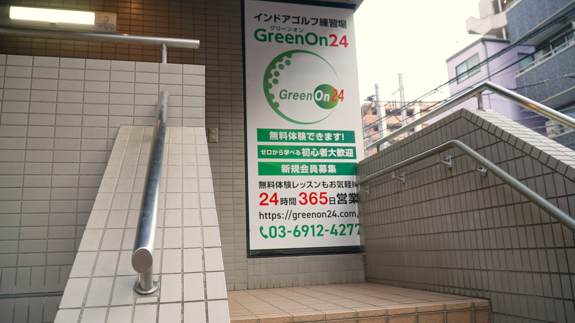 まいばすけっと横の階段。GreenOn24 の立て看板が出ています。この階段を上がります
