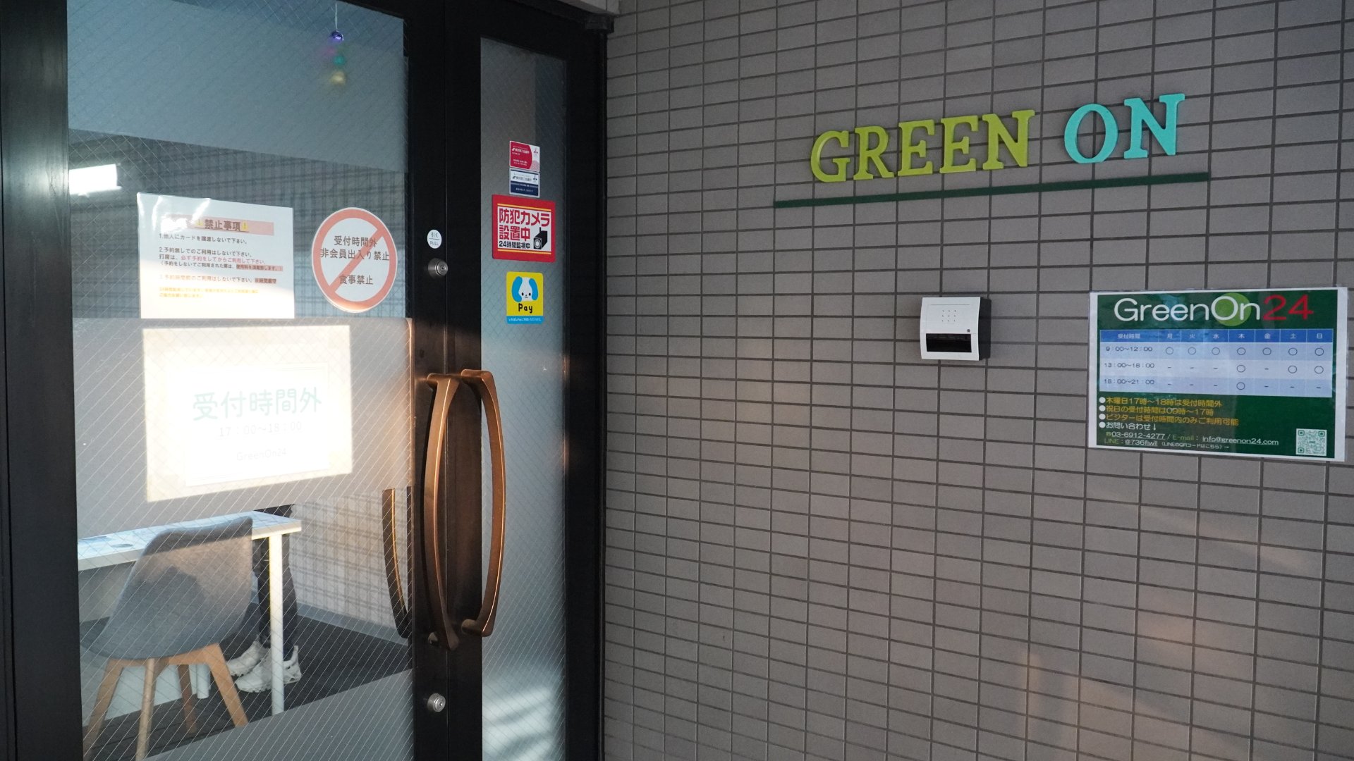 GreenOn 板橋本町の入口。スタッフ3名が入口の GREEN ON 看板の前に並んでいる
